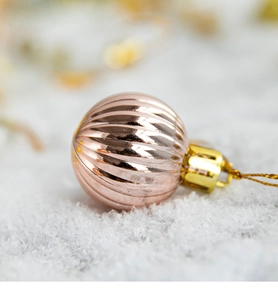 Close-up of rose gold Christmas ball ornament with elegant vertical ribbed texture