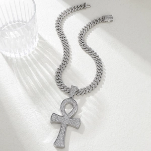 Détail du pendentif croix Ankh argentée sur une chaîne à maillons cubains glacés