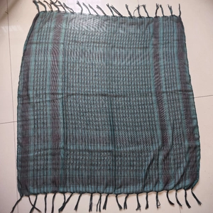 Detail of dark green checkered desert scarf with fringe tassels for outdoor hiking gear
