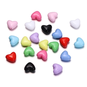 Macro shot of colorful heart-shaped acrylic beads with pre-drilled holes for DIY jewelry