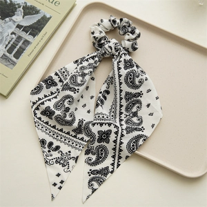 Detail of white paisley pattern hair scrunchie with long ribbon tails on a tray