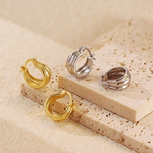 Macro shot of layered gold and silver S925 sterling silver hoop earrings on stone