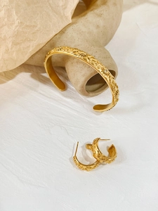 Detail of vintage gold-plated star and moon relief on open cuff and C-shaped earrings