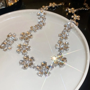 Elegant silver floral necklace and stud earrings set featuring clear sparkling crystals