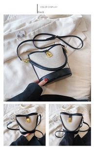 Detailed shot of two-tone bucket bag featuring cream fabric, black leather and gold hardware