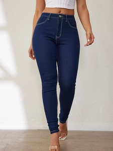 Detail of high waisted skinny jeans with contrast white stitching and metal button