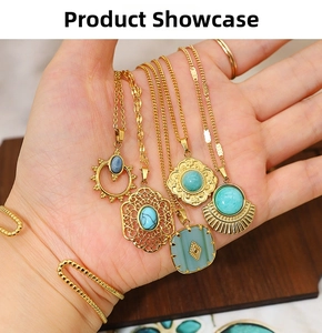 Detail of bohemian gold necklaces with turquoise pendants held against a wooden background