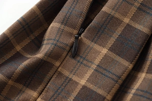 Detail view of the hidden zipper on the brown plaid mini skirt with high-quality texture
