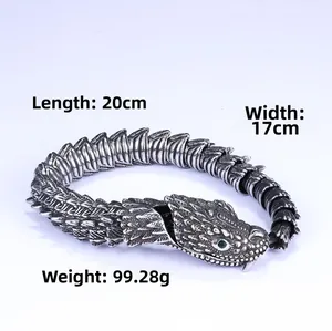 Close-up of vintage stainless steel snake bracelet with green stone eyes and scale detail