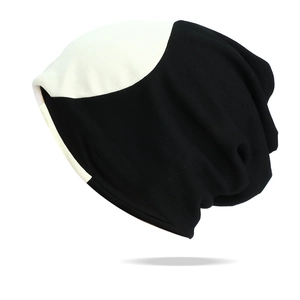 Gros plan du bonnet en maille bicolore noir et blanc montrant la texture du tissu