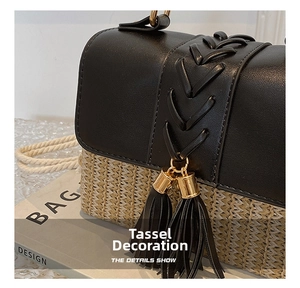 Detailed close-up of woven straw and black leather crossbody bag with tassel and gold hardware