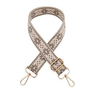 Dettaglio della tracolla larga in stile etnico geometrico con fibbie metalliche dorate