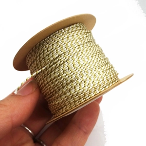 Detail of 1mm gold and white twisted cord on spool for DIY jewelry and crafts