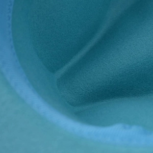 Detailed macro view of high-density turquoise felt texture on a classic fedora hat