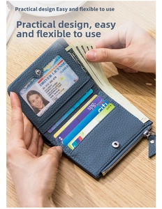 Detalle de billetera delgada de cuero azul con ranuras para tarjetas y bolsillo con cremallera