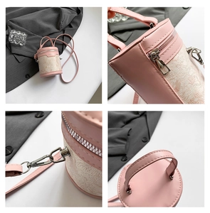 Detail view of pink bucket bag featuring metallic zipper, silver buckle, and handle texture