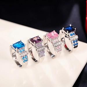 Detail showing square-cut colorful gemstones on silver rings with micro-pave setting