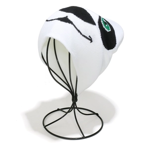 White knitted beanie with cute green and black panda jacquard pattern on a display stand