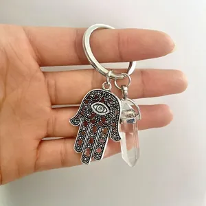 Macro view of Hamsa Hand pendant with evil eye and hexagonal quartz crystal keychain