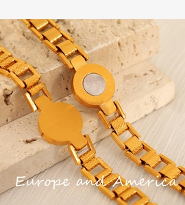 Detailed close-up of 18K gold plated bracelet with Roman numerals and white shell inlay