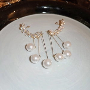 Detail of gold tassel earrings featuring sparkling zircons and dangling white pearls