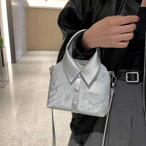 Unique silver shirt-style handbag with textured design shown in a modern corridor