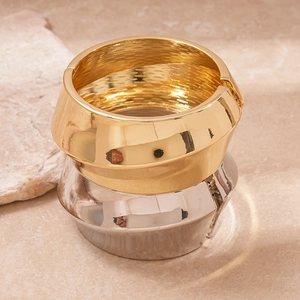 Detailed macro view of polished gold and silver metal bangles with honeycomb inner texture