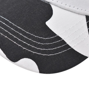 Macro view of black and white cow print cotton fabric with reinforced brim stitching