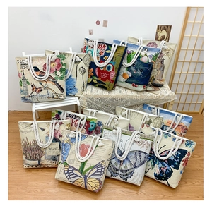 Detailed display of large canvas tote bags with floral embroidery and cotton rope handles