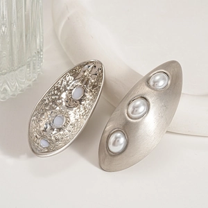 Detailed view of oval matte silver earrings with three pearls and textured finish