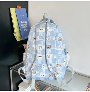 Detail of light blue plaid backpack featuring cute bear prints and adjustable straps
