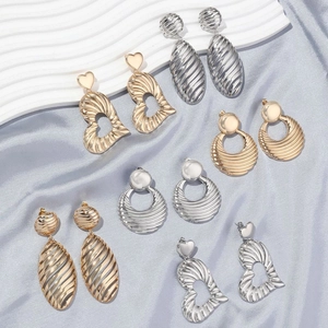 Exaggerated irregular metallic earrings in gold and silver finish with striped texture