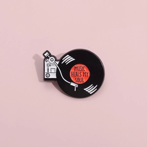 Détail de l'épingle en émail de disque vinyle avec texte Music Heals My Soul sur rose