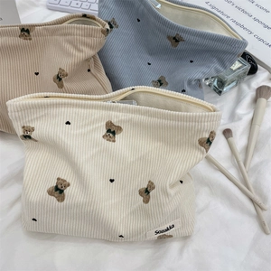 Detailed close-up of corduroy makeup bags with bear patterns in various soft colors