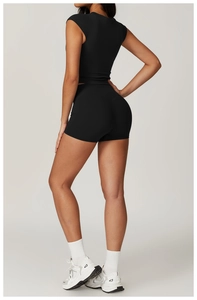 Detail view of high-waist fitness shorts and crop top with back stitching on a model