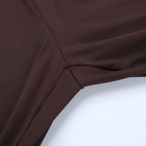 Detailed view of flatlock stitching and smooth fabric on a dark brown fitness bodysuit
