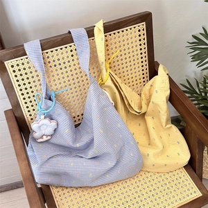 Floral cotton tote bags in blue and yellow plaid displayed on a vintage rattan chair
