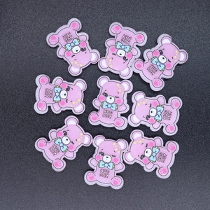Detail of purple resin bear charms for DIY crafts with Hug Me text and blue bowties