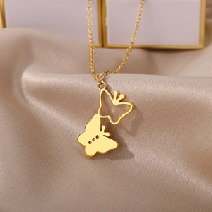 Detail of gold-plated hollow butterfly pendant on silky champagne satin background