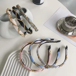 Detailed view of woven satin twist headbands with gold bead chain accents in multiple colors