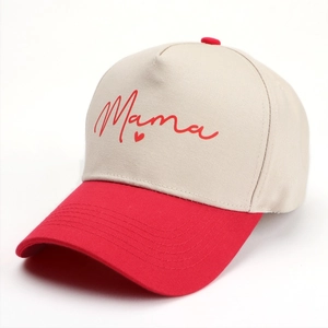 Détail de casquette bicolore avec broderie Mama rouge et cœur sur couronne beige coton