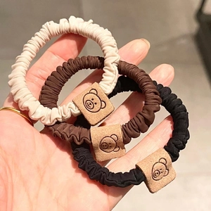 Three-piece set of pleated elastic hair ties in cream, brown, and black with cute bear tags