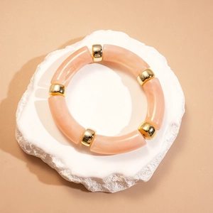 Détail d'un bracelet géométrique avec perles en acrylique marbré rose et or