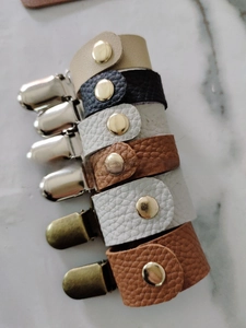 Detail von Lederhut-Clips in verschiedenen Farben mit strukturierter Optik und Metallclips