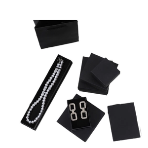 Set of black kraft jewelry gift boxes and paper bags for rings and necklaces on white background