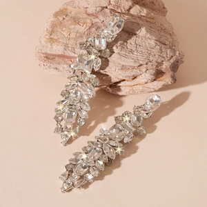 Close-up of luxury tassel earrings with sparkling crystal drops on stone