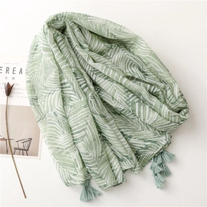 Detailed view of lightweight boho shawl with green palm leaf print and tassel fringes