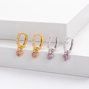Close-up of heart-shaped pink zircon earrings in gold and silver finish with micro-pavé