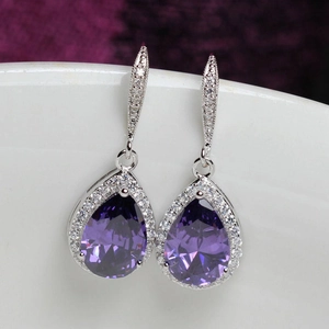Close-up of pear-cut purple zircon drop earrings with micro-pave halo setting