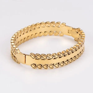 Detail of vintage gold stainless steel bracelet featuring hollow leaf patterns and clasp